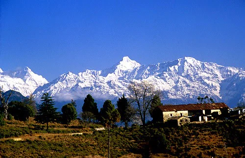 A dramatic, close-up view of the majestic, snow-capped Himalayan peaks towering above the resort.