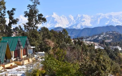 Scenic view of Hardik Resort cottages and snow-capped Himalayan mountains