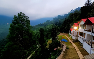 Exterior view of the cottages along a pathway overlooking the forest valley