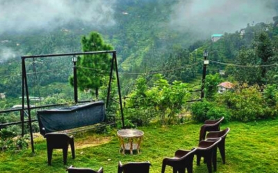 Outdoor seating area with a swing overlooking the misty mountain slopes