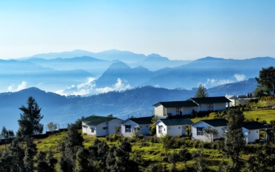 A row of well-maintained cottages or permanent tents on a misty hillside