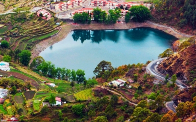 Aerial view of a reservoir lake surrounded by terraced fields and small buildings